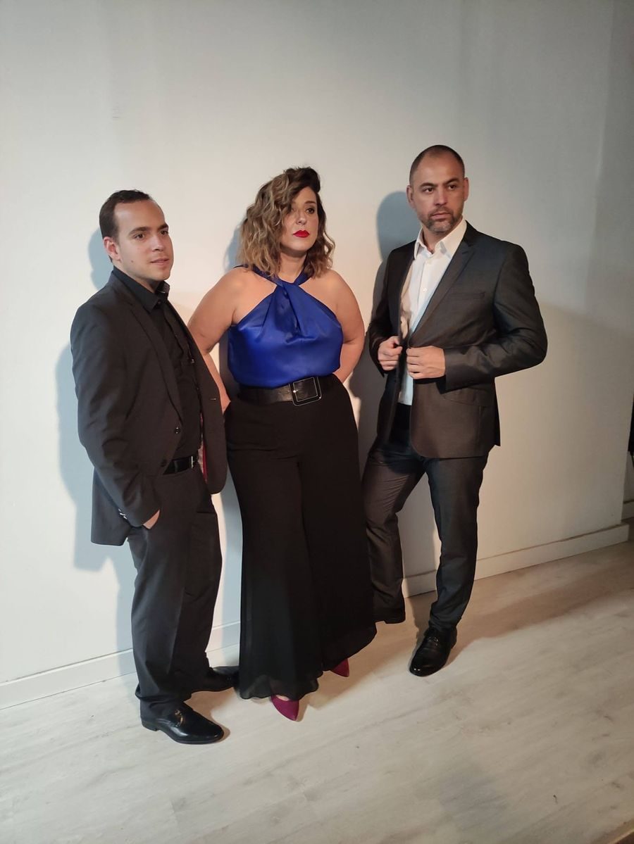 El ensemble de pie junto a una pared